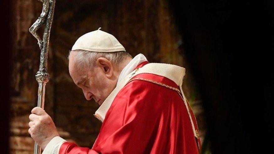 Fotografia do Santo Padre orando com vestes vermelhas sobre o seu cetro